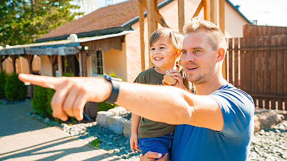 Der Vater zeigt seinem Sohn wie beeindruckend die Fahrgeschäfte im FORT FUN Abenteuerland sind.